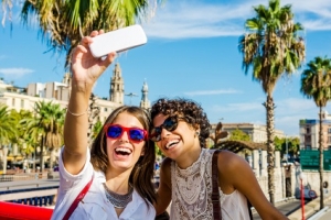 Two friends taking a photo with smartphone in the city
