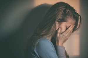 A woman sitting alone and depressed in sunset