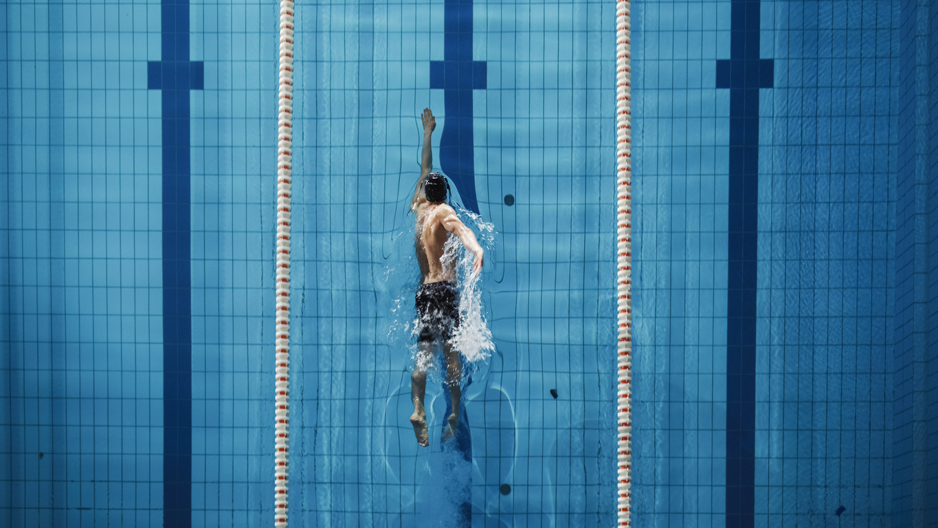 Aerial Top View Male Swimmer Swimming in Swimming Pool. Professional Athlete Training for the Championship, using Front Crawl, Freestyle Technique